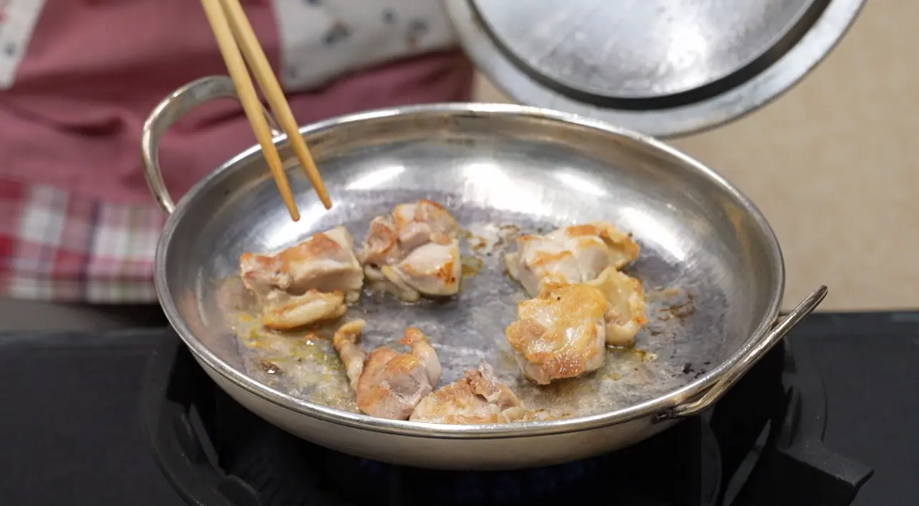 銀のフライパンで鶏肉を焼いてます